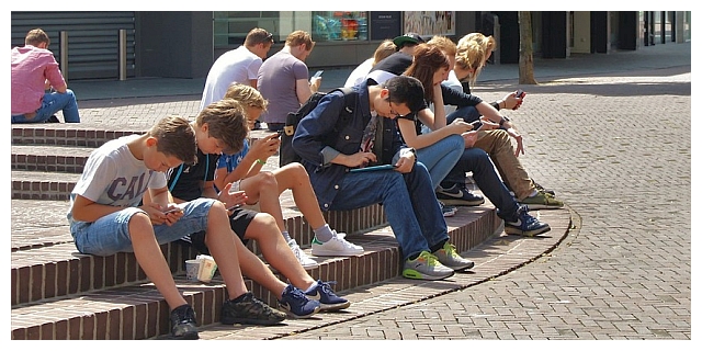 Eine Gruppe Teenager sitzt auf einer Treppe im Freien.